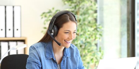 Eine Frau sitzt vor einem Laptop und arbeitet